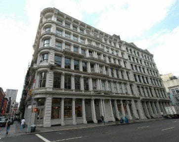 A large historic building with ornate architecture on a street corner.